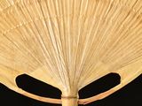 a close up of a bamboo umbrella with a black background