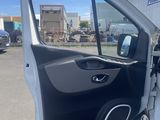 the door of a white van is open in a parking lot
