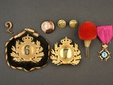 trois médailles, une médaille et un pin's posés sur une table