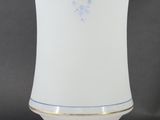 a white vase with a gold decoration on it