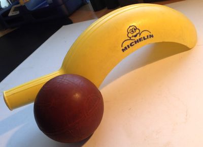 une banane et une balle rouge posées sur une table