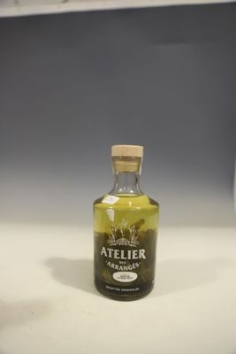 a bottle of olive oil sitting on a counter next to a glass of wine