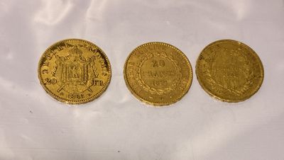 three gold coins sitting next to each other on a white surface