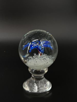 une boule de verre contenant un crabe bleu