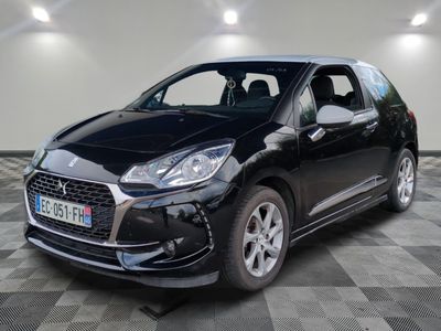 la voiture noire est garée sur un sol en damier dans le garage