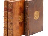 deux vieux livres posés l'un sur l'autre sur une surface blanche