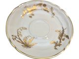 a white and gold saucer with gold flowers on it