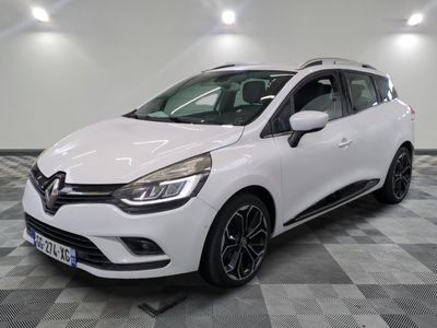 a white car is parked on a checkered floor in a garage