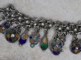 a close up of a silver bracelet with multi colored beads