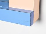 a blue and pink shelf with a clock on it