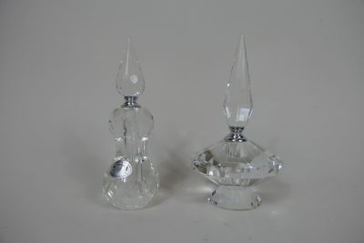 deux bougeoirs en cristal posés sur une table blanche