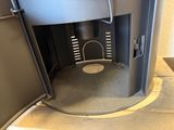 a toilet in the middle of a small room with a door open