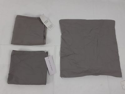 trois vêtements disposés sur une surface blanche