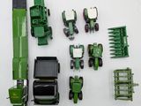 a green toy tractor and other farm equipment on a white surface