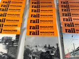 four magazines of rail magazines on a table with a train in the background