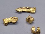 trois pièces d'or sont représentées sur une surface grise