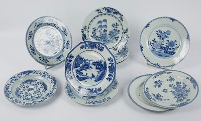 plusieurs assiettes et bols bleus et blancs posés sur une surface blanche