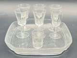 a tray with four glasses on it on a table