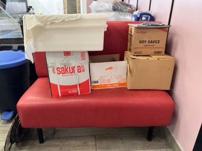 un banc rouge sur lequel sont posées des boîtes, dans une pièce