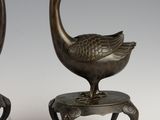 pair of bronze ducks on a stand
