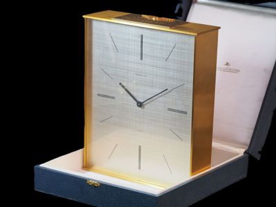 une horloge posée dans une boîte sur une table