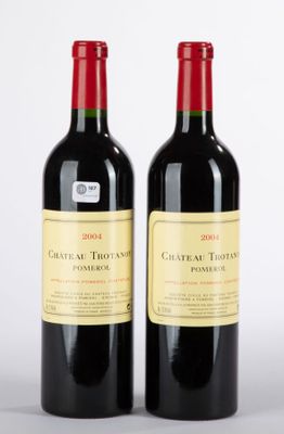 deux bouteilles de vin rouge posées l'une à côté de l'autre sur une surface blanche