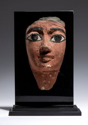 un gros plan d'un masque en argile sur fond noir
