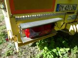 a yellow truck with a red tail light on it ' s side