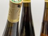 several bottles of wine are lined up on a white surface
