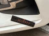 a ruler on the front bumper of a white car