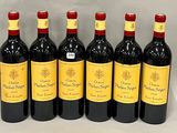 six bottles of red wine lined up in a row on a table