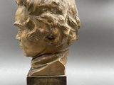 bronze bust of a young man on a wooden base