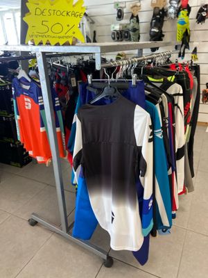 un portemanteau dans un magasin, sur lequel est accrochée une pancarte
