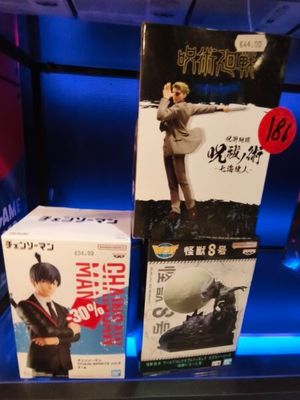 trois boîtes de figurines exposées dans un magasin