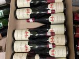 bottles of wine sit in a cardboard box on the floor