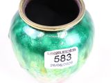 a green vase with a tag on it on a white surface