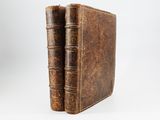 an old book sitting on top of a white surface