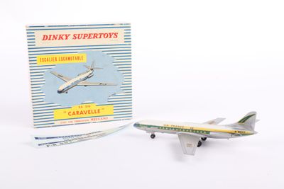a toy airplane sitting next to a book on a white surface