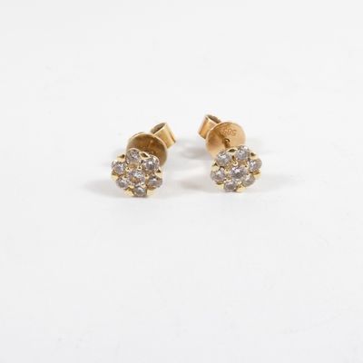a pair of diamond stud earrings on a white background