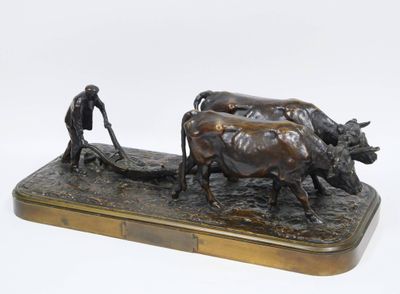 sculpture en bronze représentant un homme labourant un champ avec deux vaches