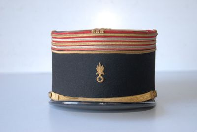 a black hat with a red and gold stripe on it