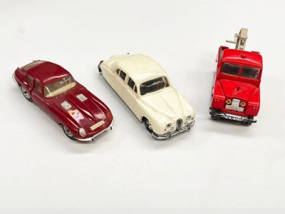 trois petites voitures assises l'une à côté de l'autre sur une surface blanche