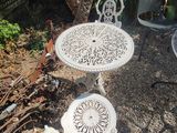 a white table and two chairs in a garden
