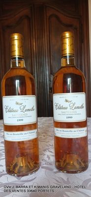 deux bouteilles de vin posées sur une table devant une porte en bois