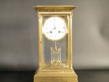 a gold clock on a black table with a gray background