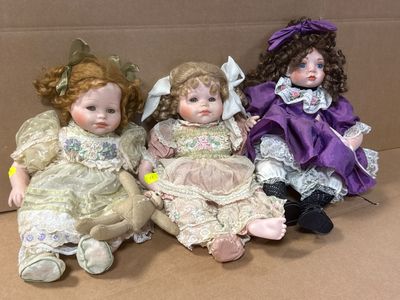 trois poupées qui sont posées dans une boîte en carton