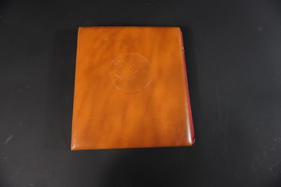 un carnet en cuir marron avec un logo sur la couverture