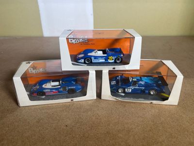 three model cars in boxes on a table