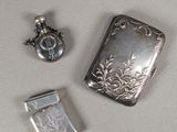 a silver flaskt and a silver lighter on a table