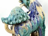 a blue and green statue of a horse and a dog